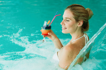 Woman enjoying hydrotherapy and cocktail