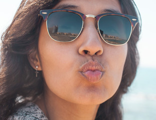 young woman sending a kiss in the beach