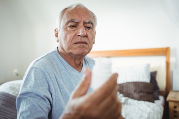 Senior man looking at pill bottle