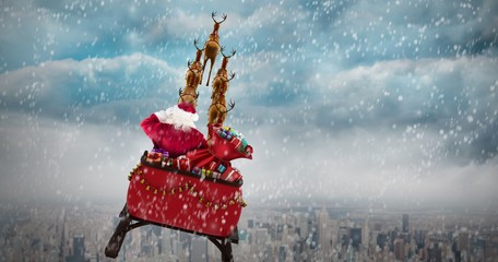 Composite image of rear view of santa claus riding on sled - Powered by Adobe