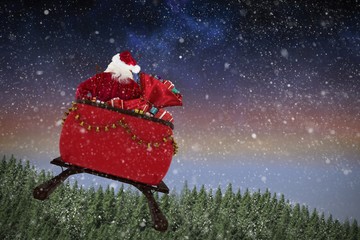Composite image of rear view of santa claus riding on sled with 
