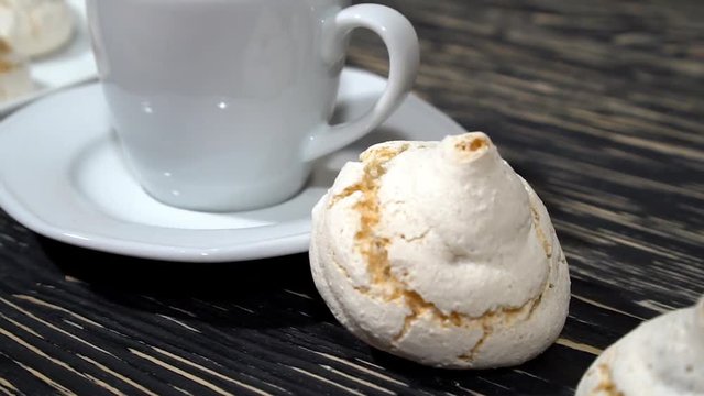 lot of white meringue cakes with coffee