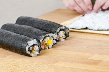 The process of making sushi and rolls.