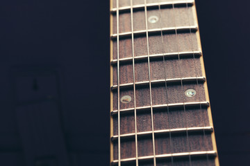 Electric guitar body and neck detail on wooden background