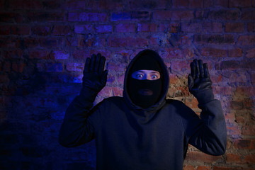 Fototapeta na wymiar Surprised thief with hands up
