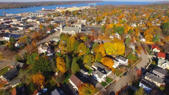 Crisp Autumn aerial flyover of scenic church in town by the water.
