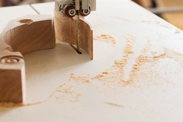 Carpenter tools on wooden table with sawdust. Band-saw to cut an intricate shape in a piece of wood.