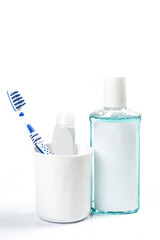 Toothbrushes in glass on table on light background