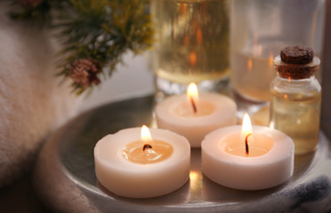 Fototapeta na wymiar Candles with spa oil and Christmas decorations, closeup