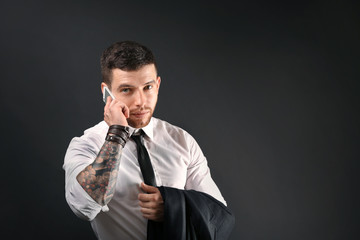 Young tattooed man posing on dark background