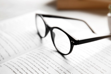Glasses on open book, close up view. Healthy eyes concept