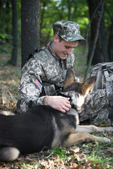 Soldier with german shepherd dog in forest