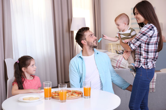 Happy Family Eating Food On Kitchen