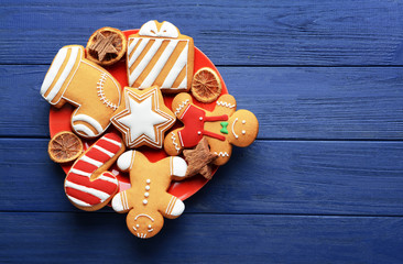 Plate with tasty Christmas cookies on wooden table