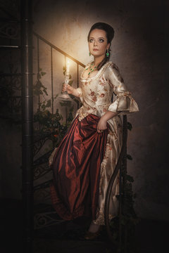 Beautiful woman in historic medieval dress with candle