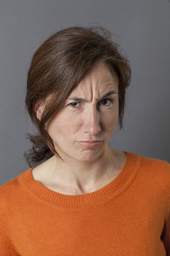 frowning woman having doubts complaining and grumbling with irritation