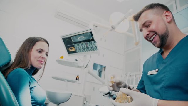The patient and the doctor pleasantly chatting and laughing. Dentistry. At the dentist's office. Therapist. Orthodontist tells the patient about the wisdom teeth.