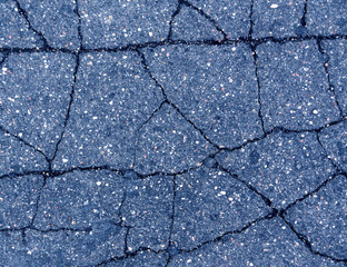 Damaged blue toned old asphalt road.