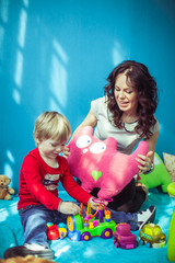 Naklejka premium little cute boy and his mother playing together