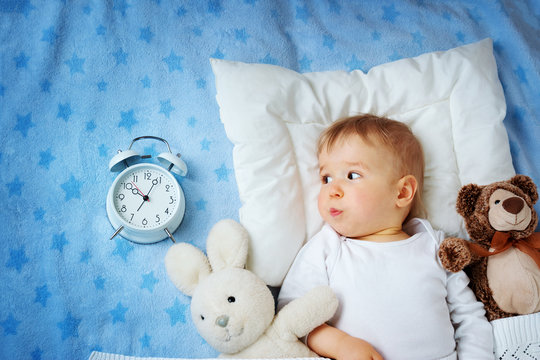 One year old baby with alarm clock