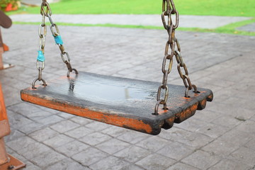 Old wooden swing in playground, close up
