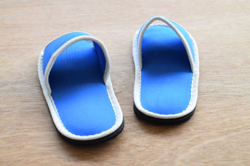 Blue house slippers on wooden background