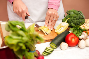 Bell pepper sliced with a knife on cutting board