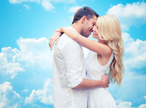 happy couple hugging over blue sky
