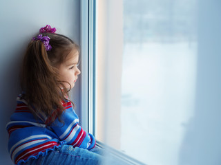 Little girl look out of the window