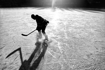 hockey player on the ice on sunset - black and white photo