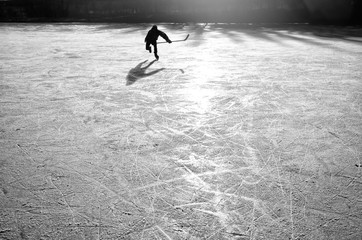 Obraz premium hockey player on the ice on sunset - black and white photo