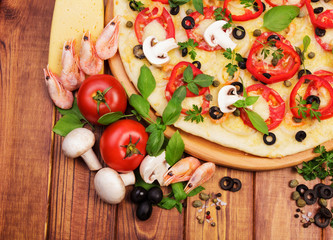 Wooden board with pizza on background of dark wood.