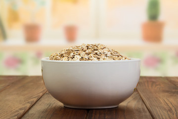 Bowl of oatmeal on background kitchen.