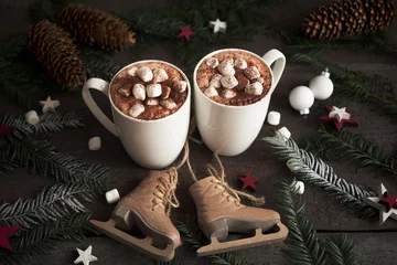 Photo sur Plexiglas Chocolat Two cups of hot cocoa or hot chocolate with marshmallows with fir tree and skates, traditional beverage for winter time. Christmas concept.