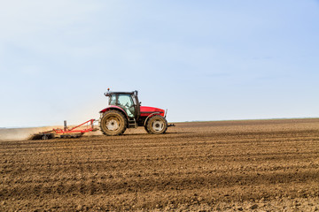 Farmer in tractor preparing land with seedbed cultivator