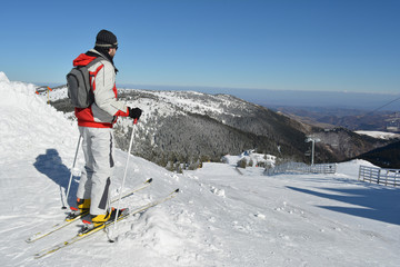 Fototapeta na wymiar Young sportsman at the top of the ski slope