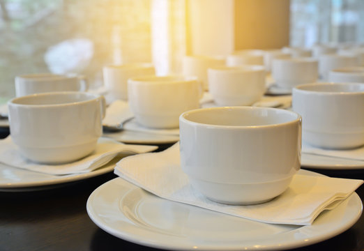 Many  white coffee cups  waiting for  serving with sun light eff