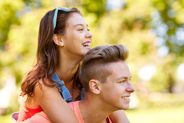 happy teenage couple having fun at summer park