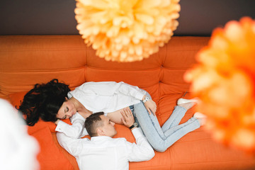 beautiful and gentle pregnant woman with her husband lying on th