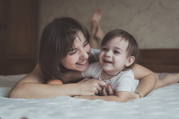 young dark haired mother and daughter Toddler playing, cuddling
