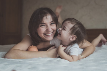 young dark haired mother and daughter Toddler playing, cuddling