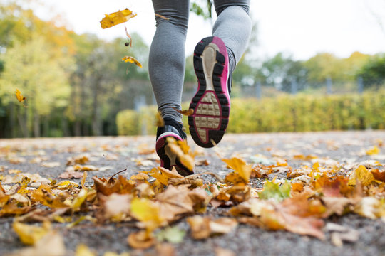 Close Up Of Young Woman Running In Autumn Park