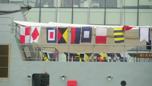 Different kinds of flags on the side railings of the ship in the river in Dublin Ireland
