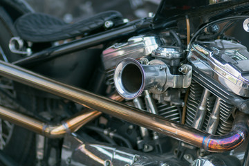 Fototapeta na wymiar Motorcycle engine close-up. Chrome, shiny parts, wheels, exhaust.