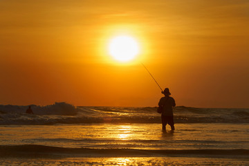 fishing on the beach at sunset