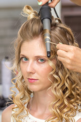 Fototapeta premium Hair stylist makes the bride before wedding