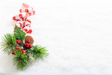 Fototapeta na wymiar Candy canes and christmas decoration on snow