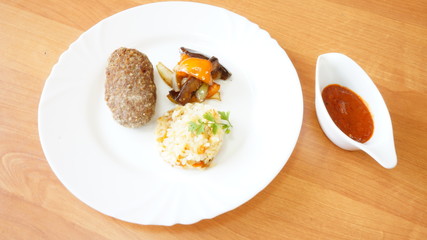 Бифштекс с гарниром из риса и овощами