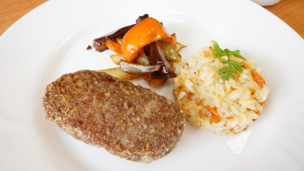 Бифштекс с гарниром из риса и овощами