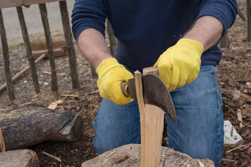 Gloved Hands Trimming Firewood with Machete